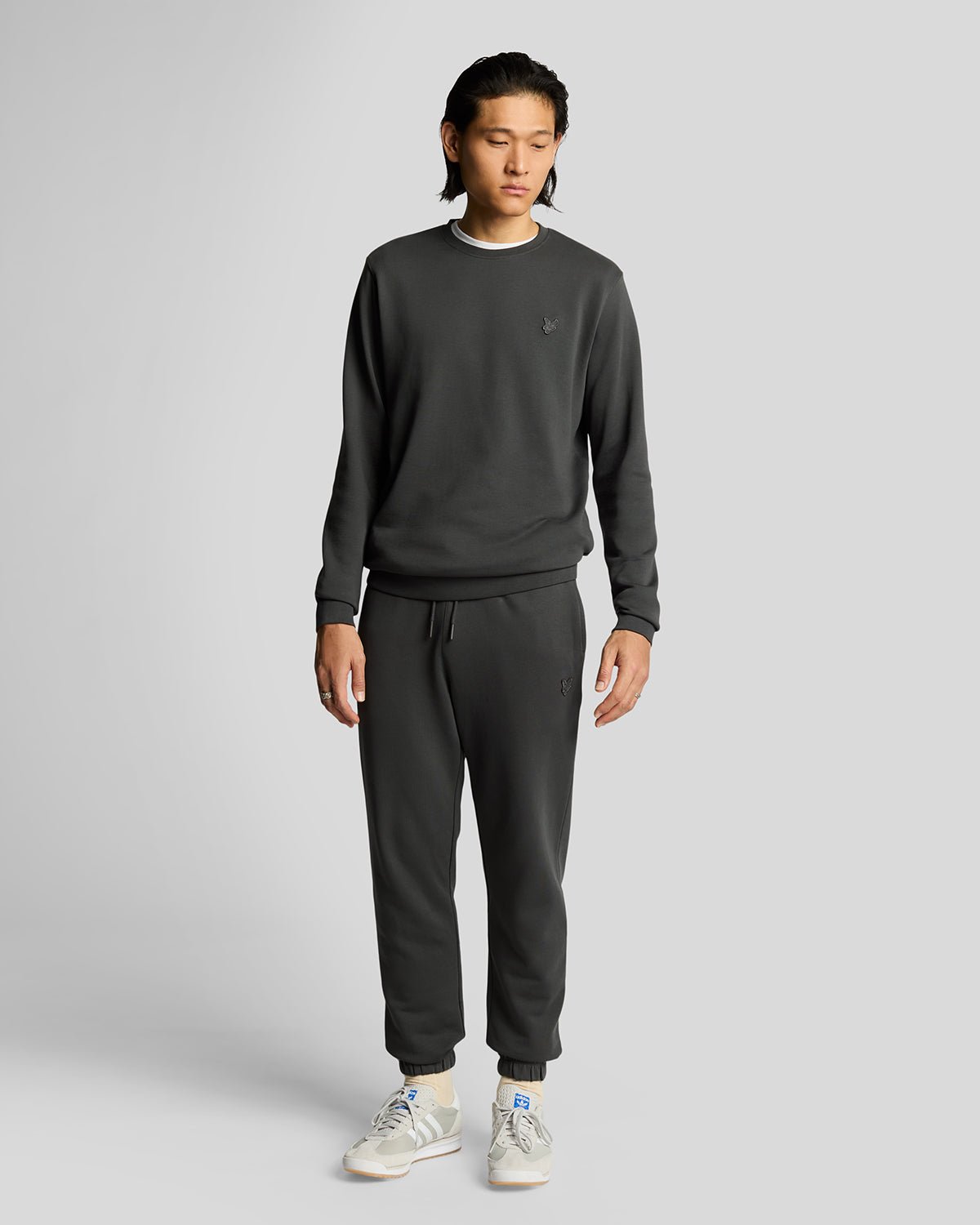 Un homme porte un pantalon de jogging slim en coton ultra-fin, couleur gris métallisé