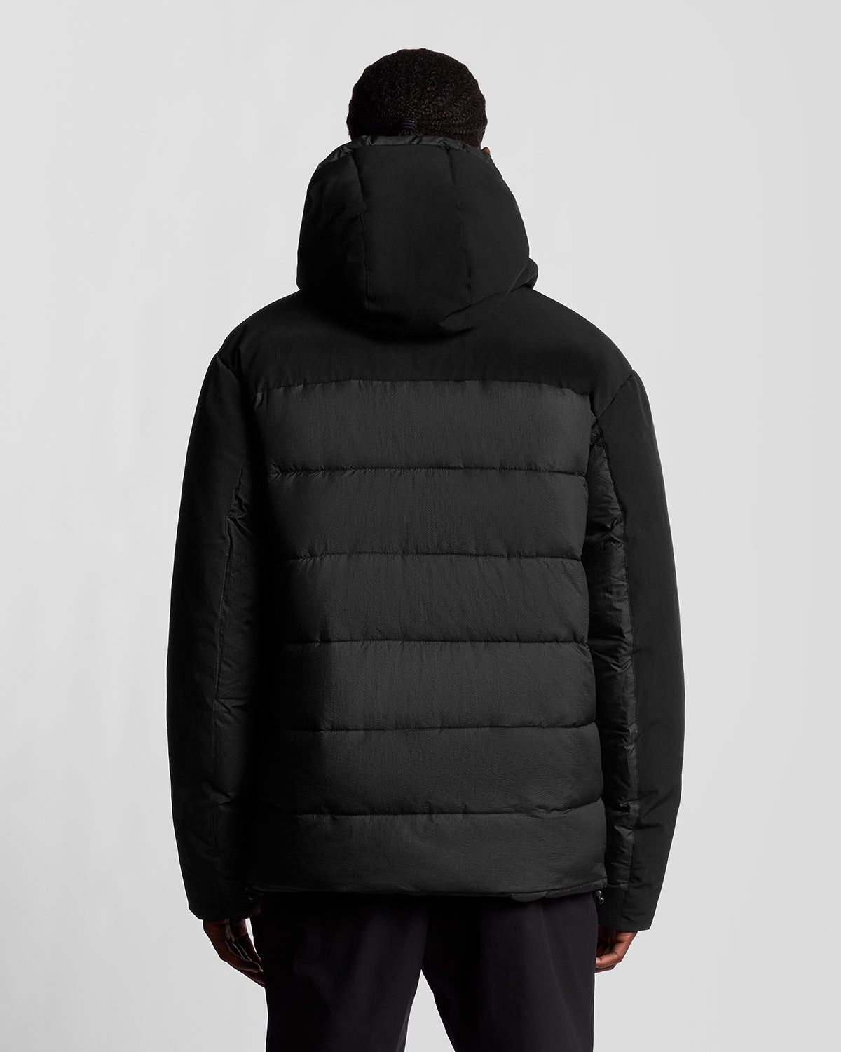 Man draagt een Sports Hybrid-pufferjack in Jet Black