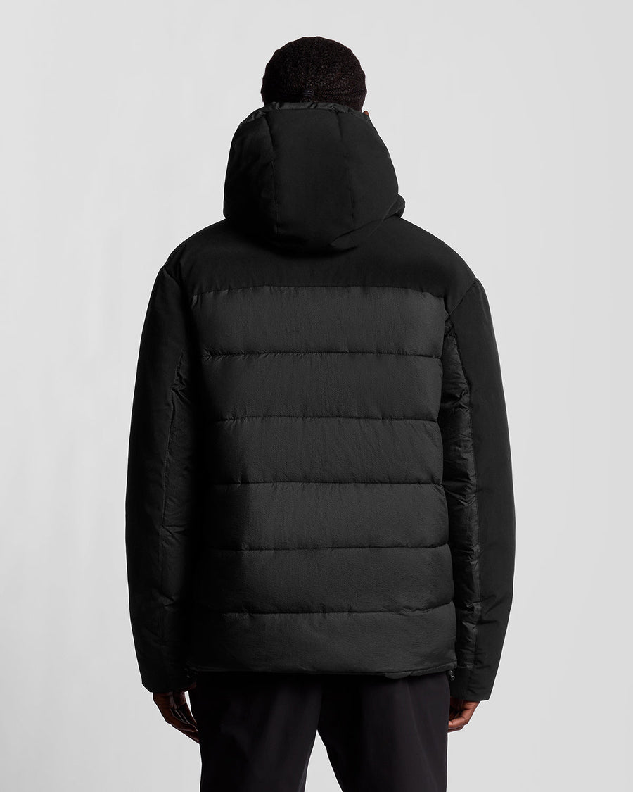 Man draagt een Sports Hybrid-pufferjack in Jet Black