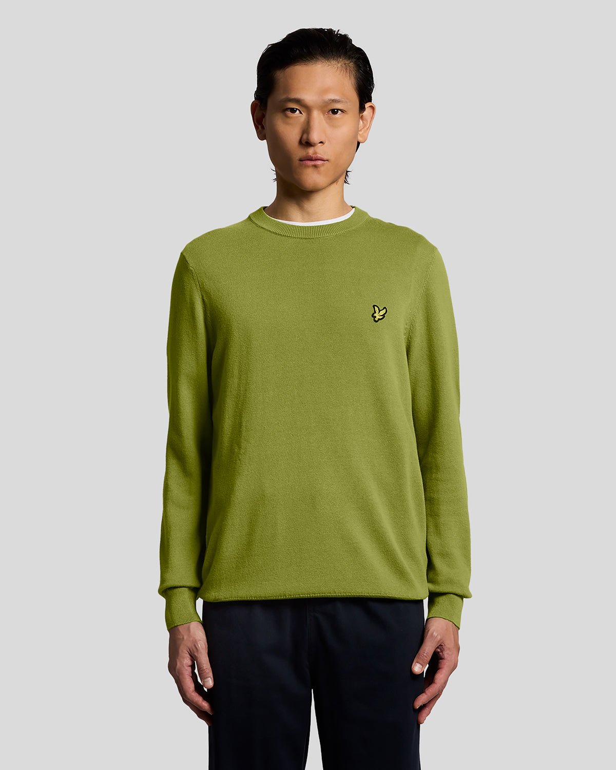 Homme portant un pull à col rond en coton vert buisson