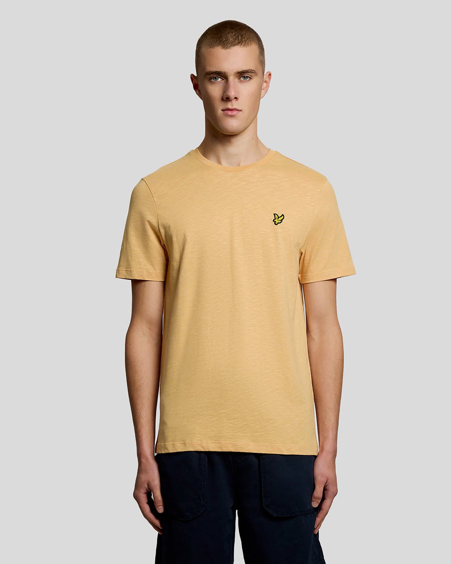 Un homme porte un t-shirt en coton fin texturé, motif nid d'abeille