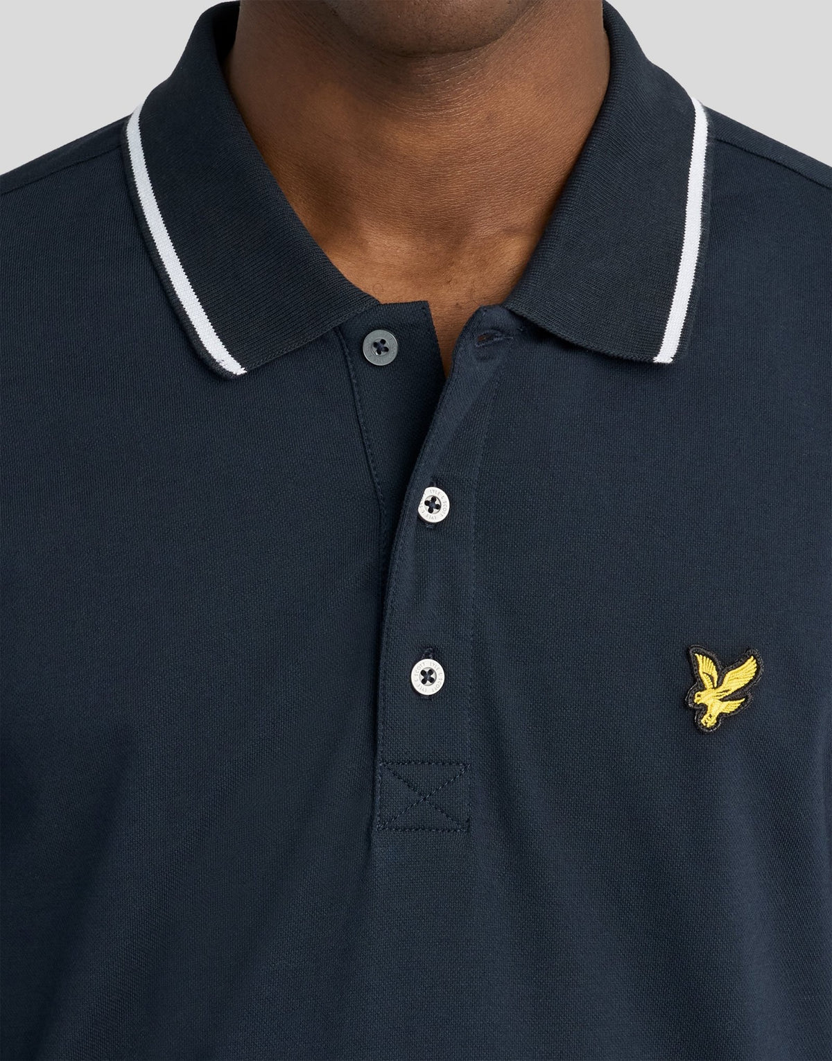 Man wears Tipped Long Sleeve Polo Shirt in Dark Navy/ White