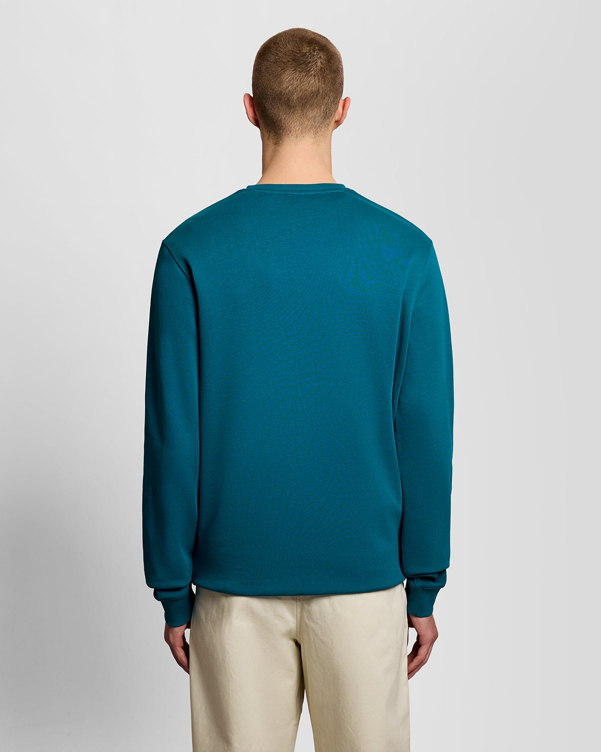 Un homme porte un sweat-shirt à col rond en coton, couleur Lagoon
