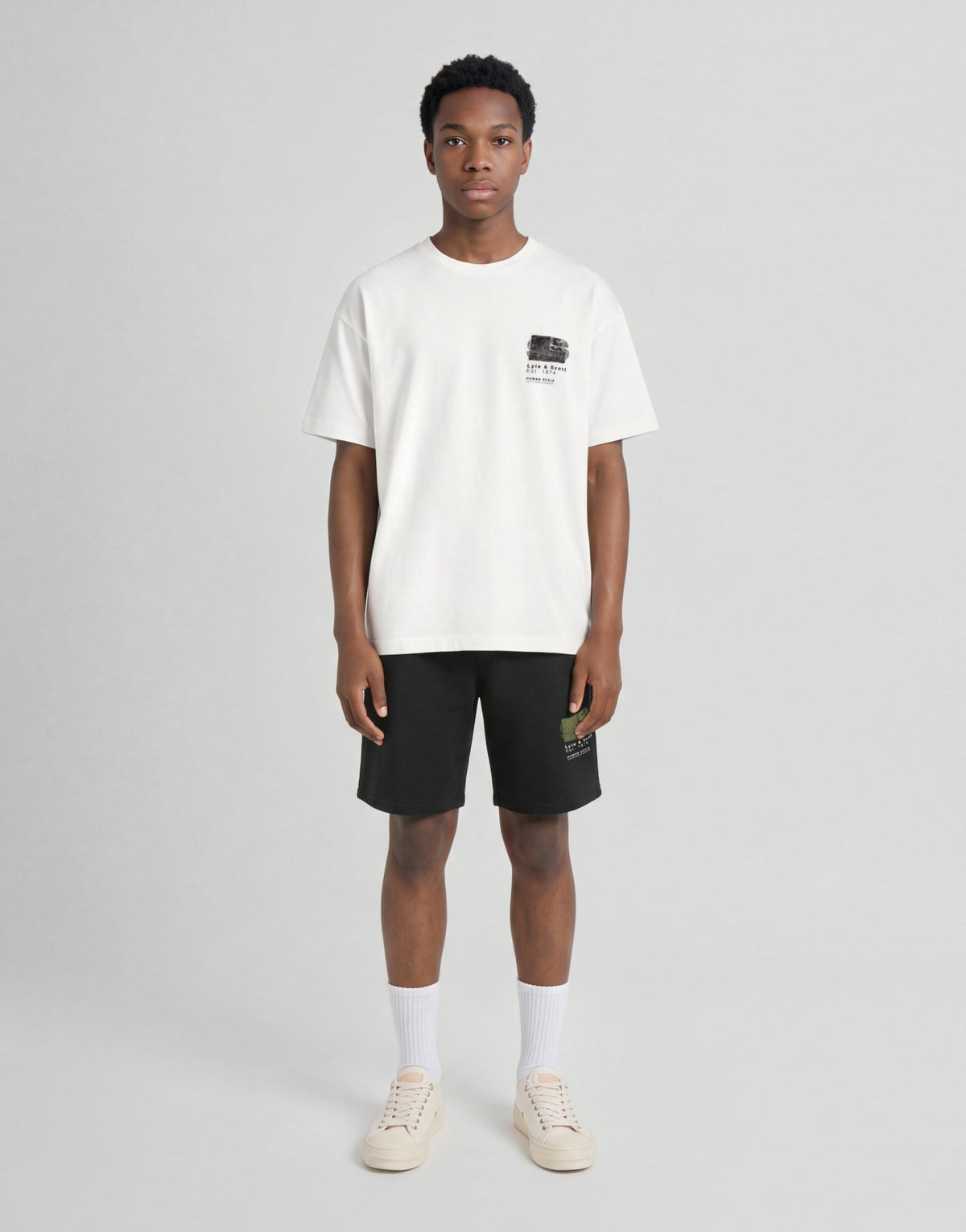 Pojke bär en vit T-shirt med halvtonat monogramtryck