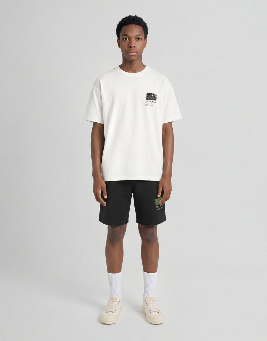 Pojke bär en vit T-shirt med halvtonat monogramtryck