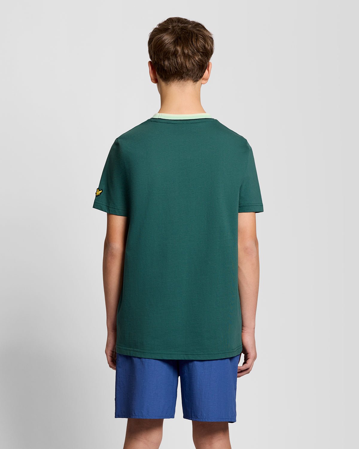 Un homme porte un t-shirt à col relevé avec logo, couleur Everglade