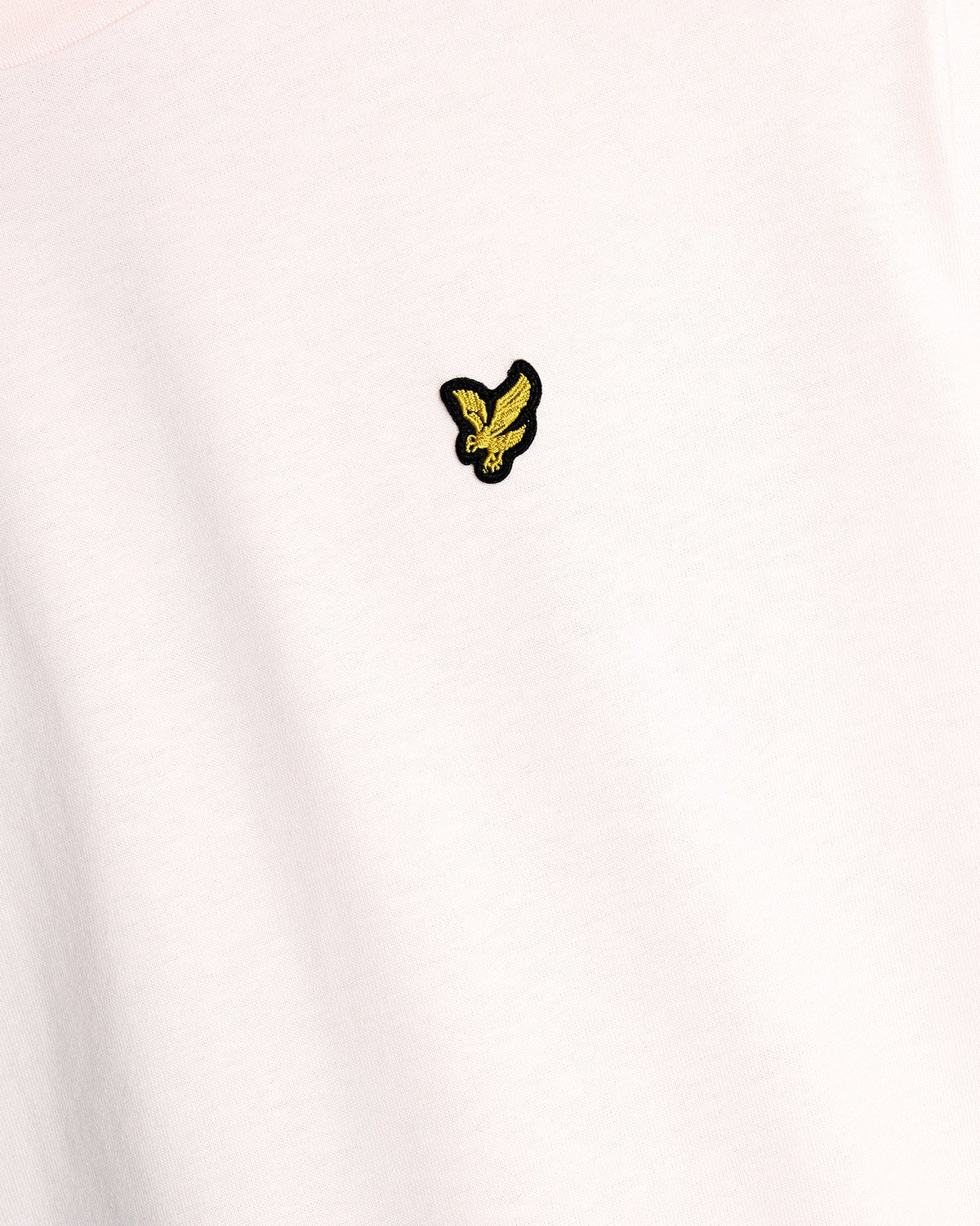 Un homme porte un t-shirt à col rond en coton rose pâle