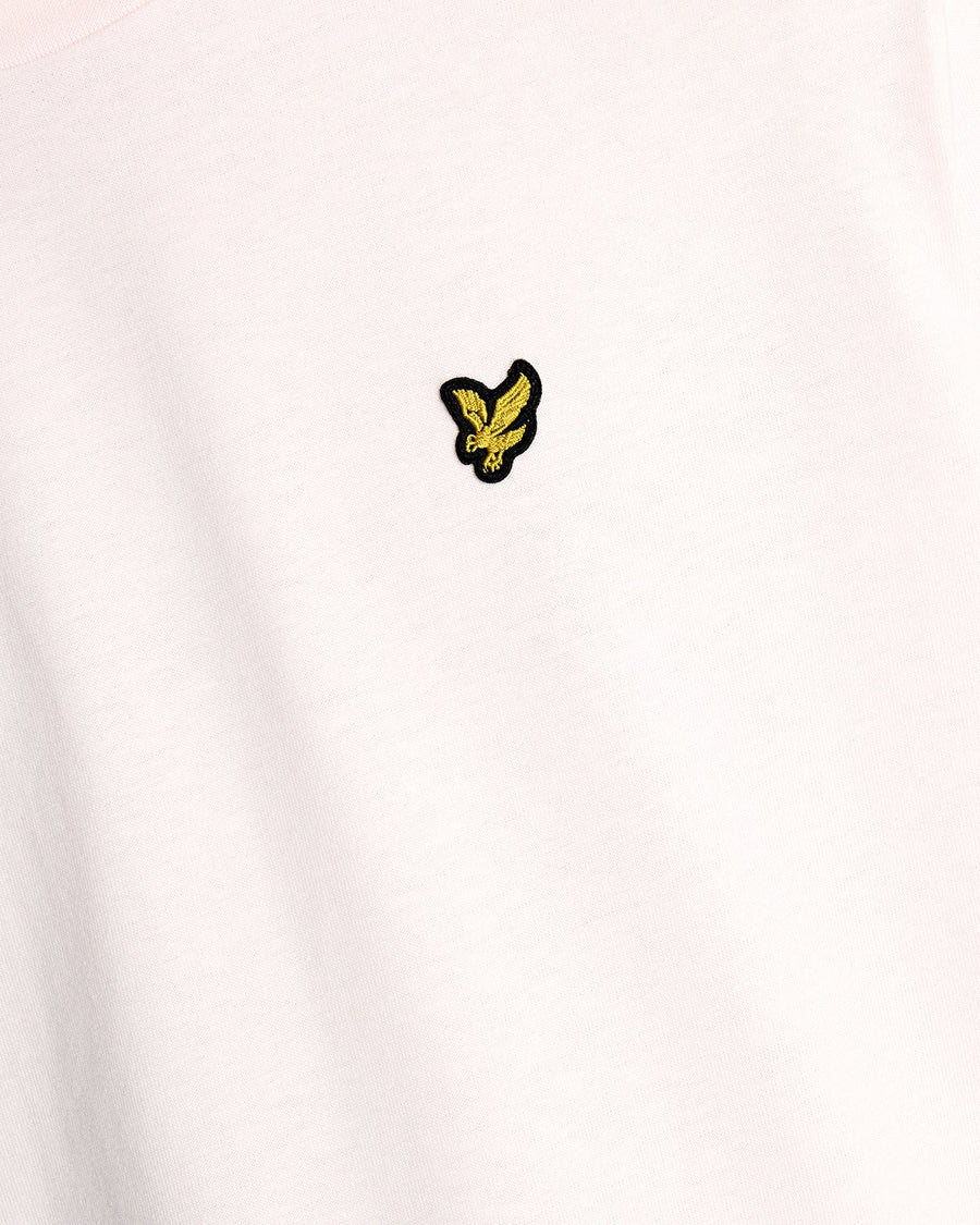 Un homme porte un t-shirt à col rond en coton rose pâle