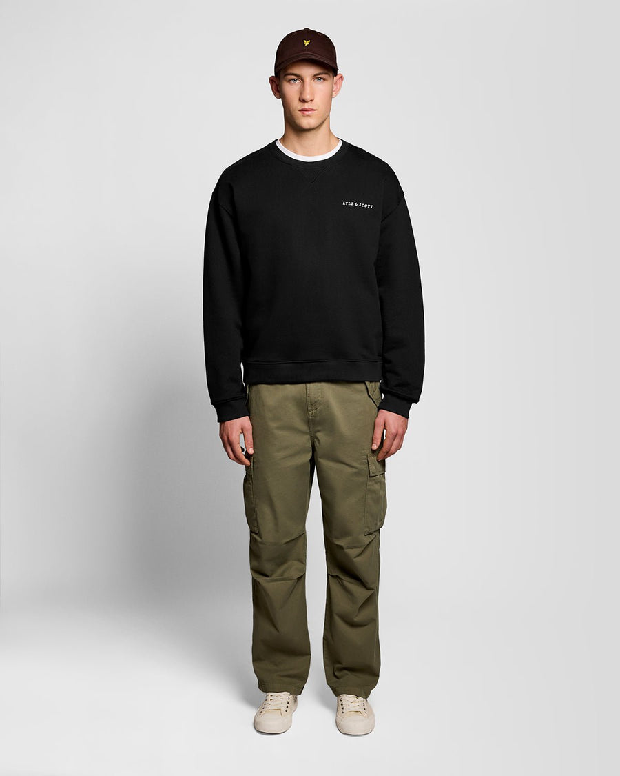 Un homme porte un sweat-shirt épais à imprimé script, couleur noir de jais