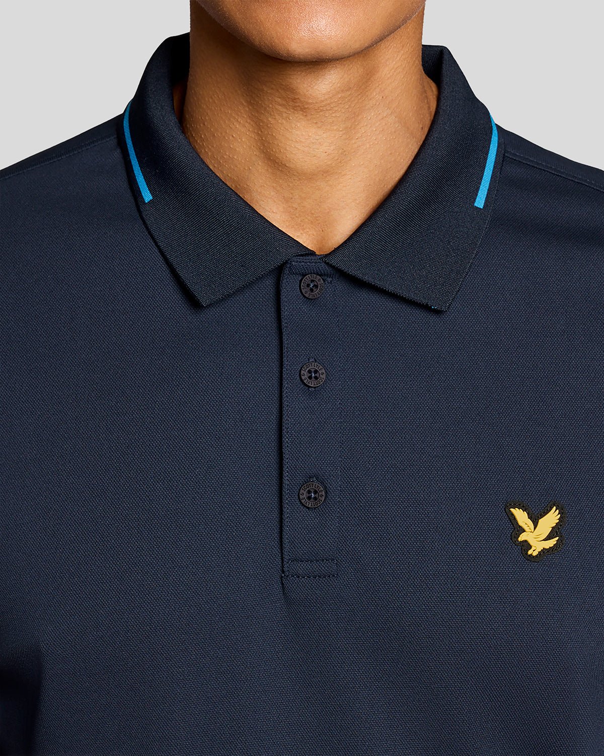 Un homme porte un polo technique à bordures contrastées bleu marine foncé
