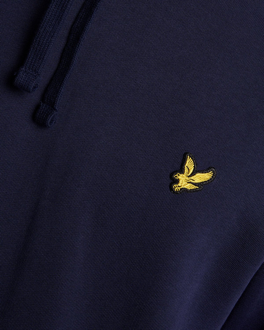 Un homme porte un sweat à capuche en coton Loopback bleu marine