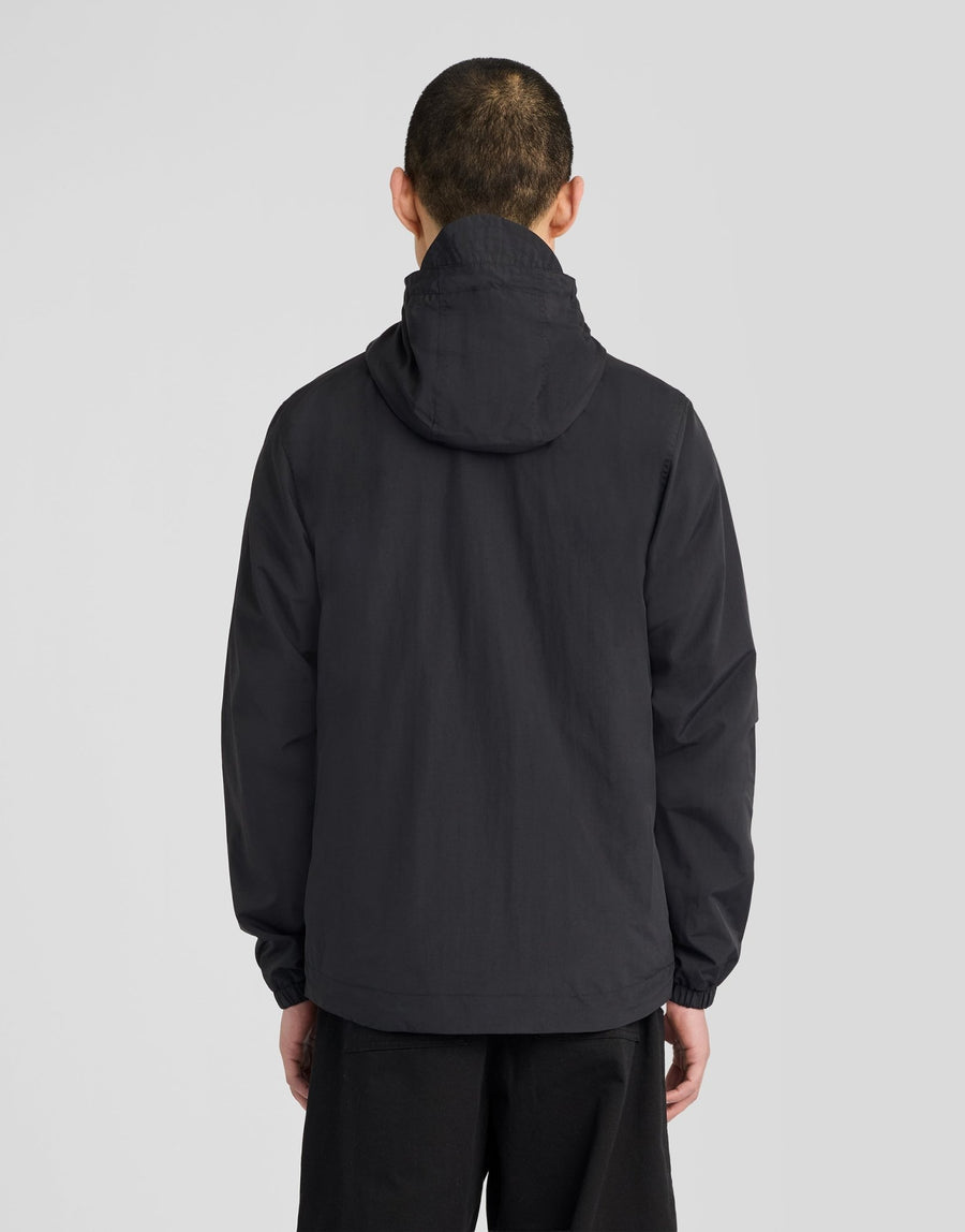 Hombre con chaqueta con capucha impermeable y costuras selladas en negro azabache