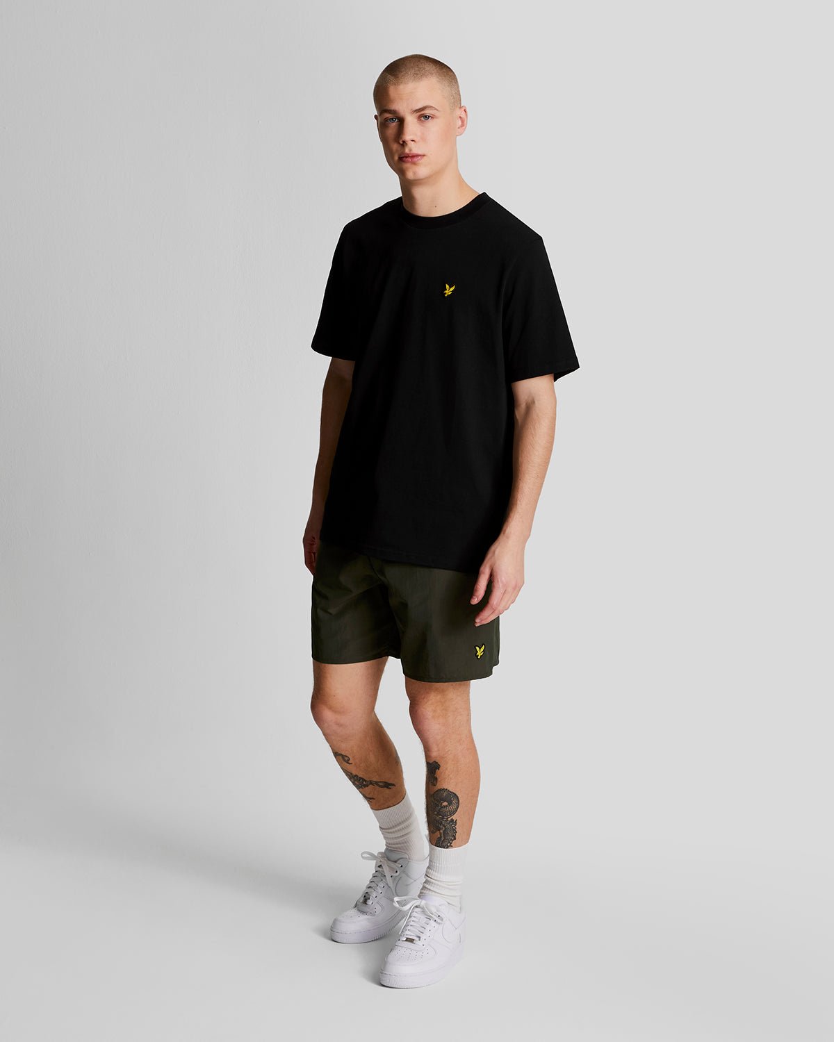 Man wears Plain Swim Shorts in Olive