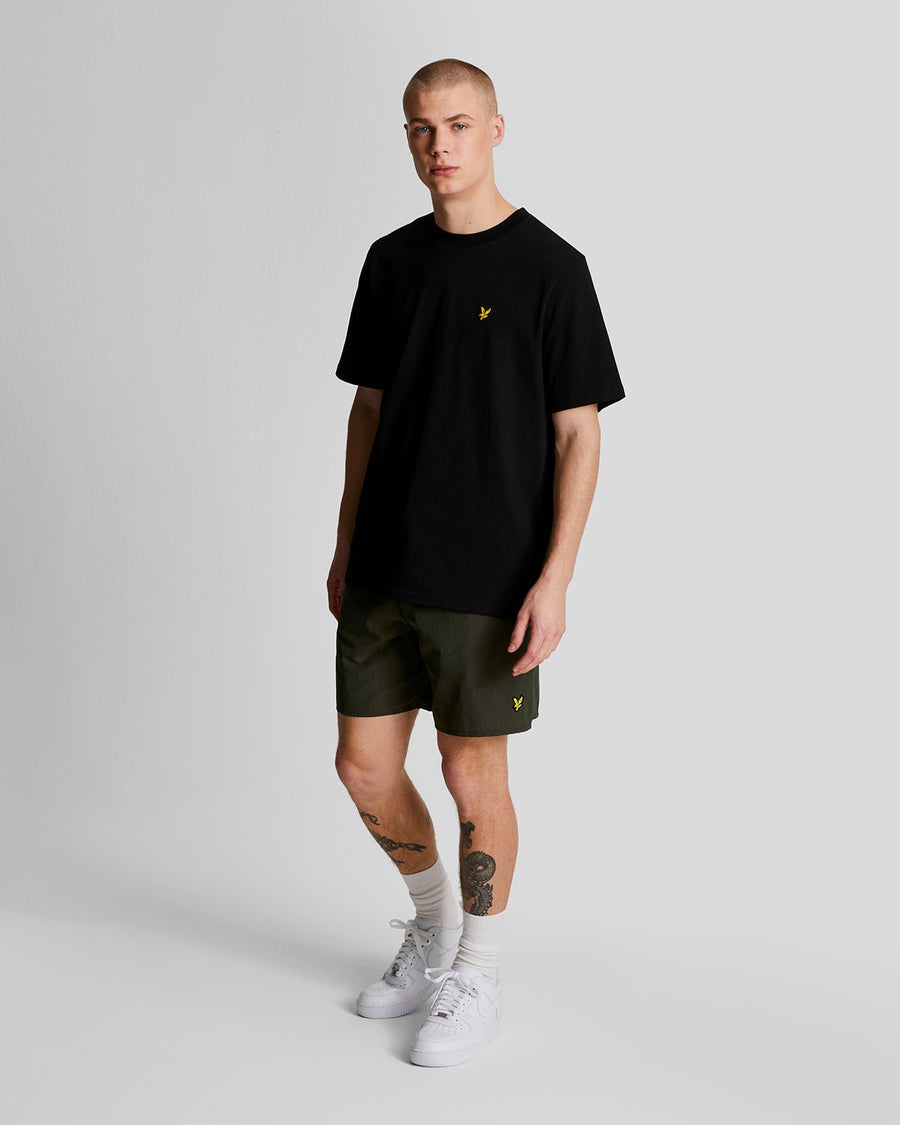 Man wears Plain Swim Shorts in Olive