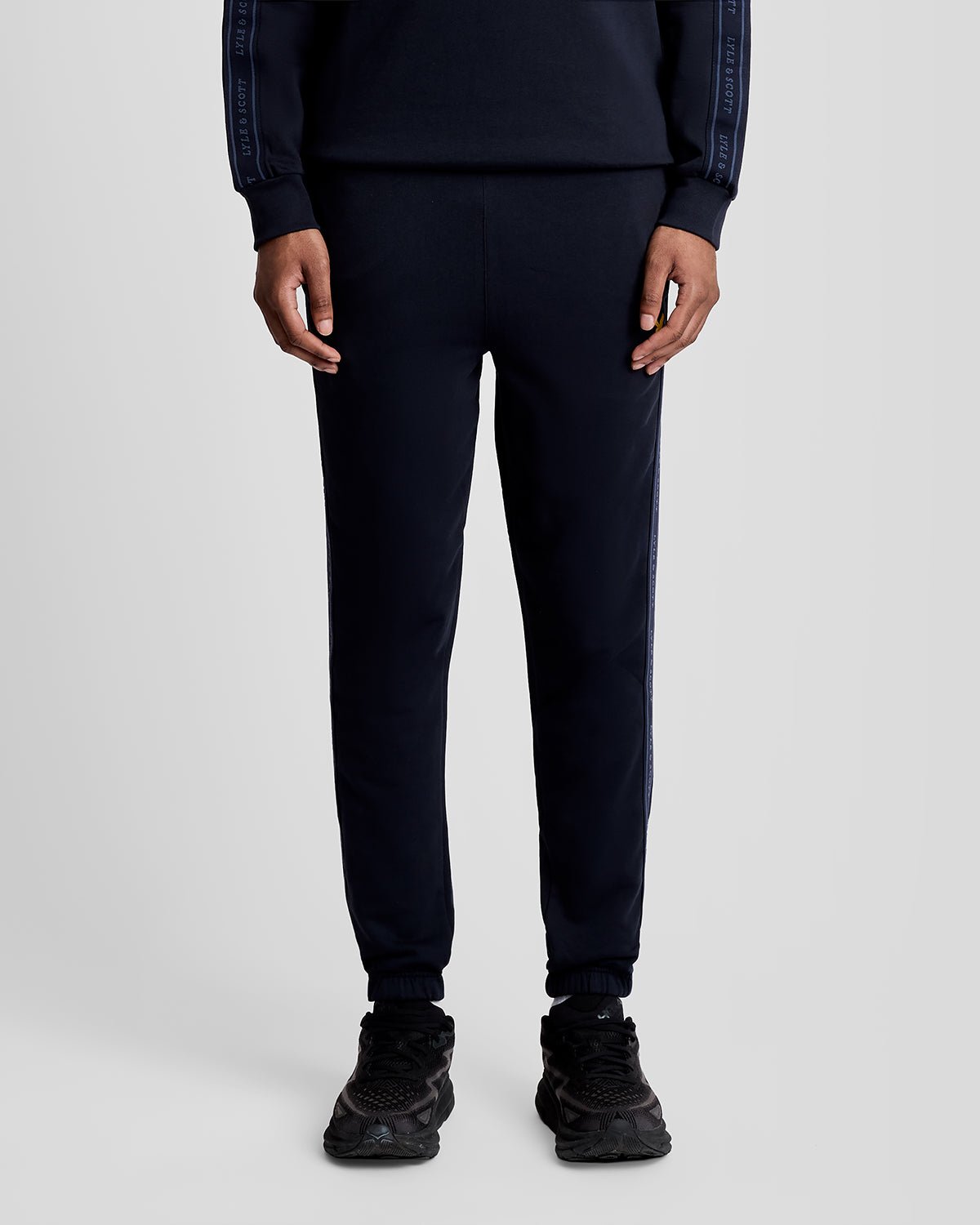 Un homme porte un pantalon de jogging Sports Tape bleu marine foncé