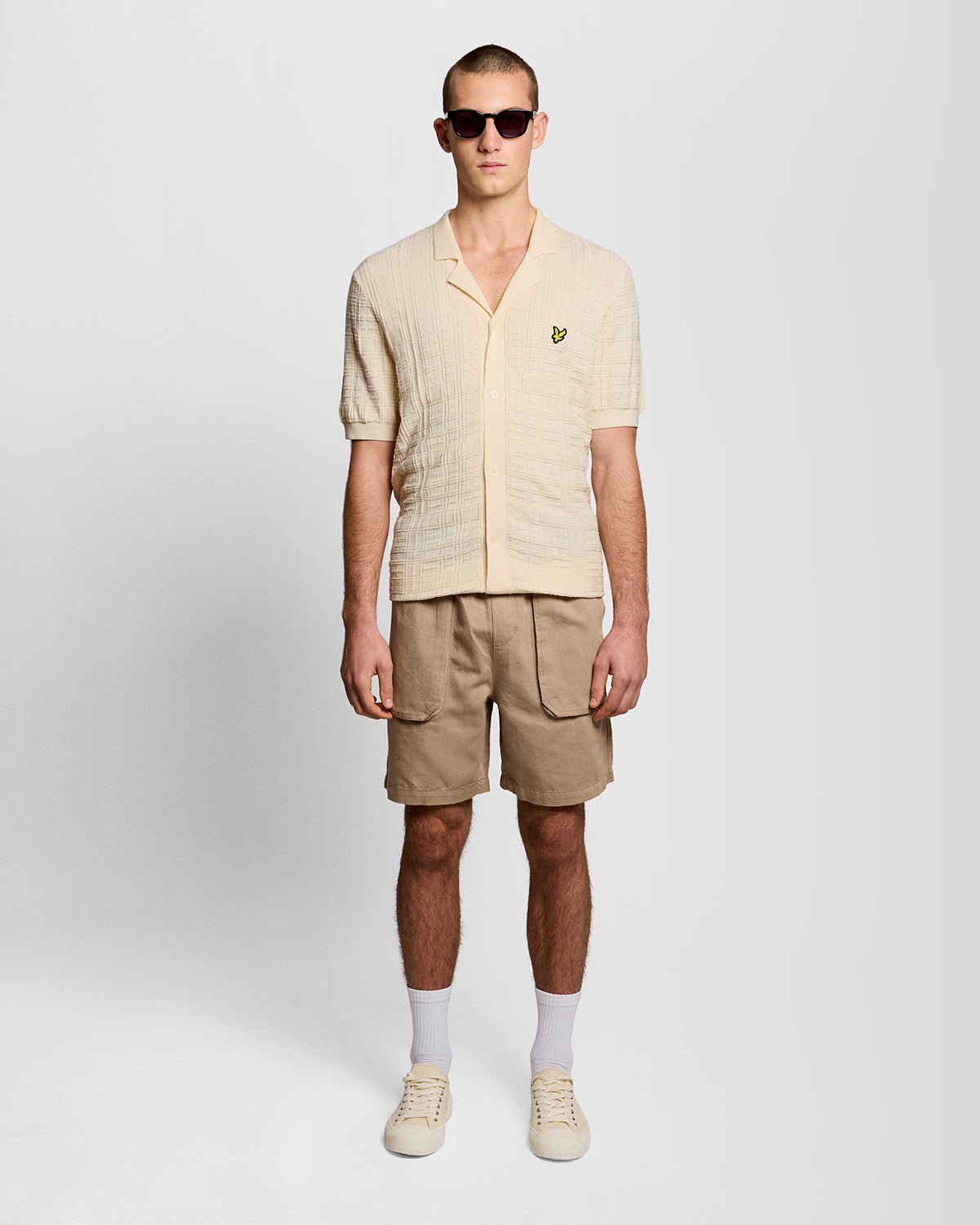 Un homme porte une chemise de vacances en maille à col Revere, couleur « Ice Cream »