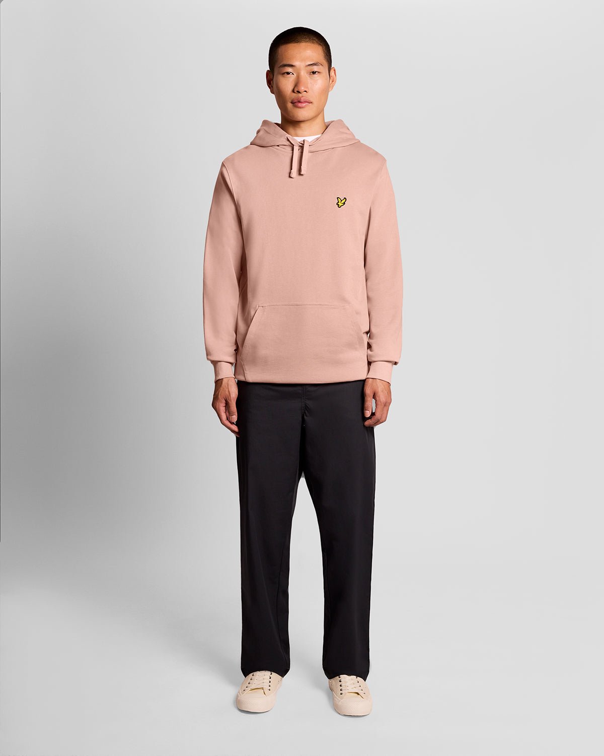 L'uomo indossa una felpa con cappuccio Loopback in cotone color rosa pompelmo