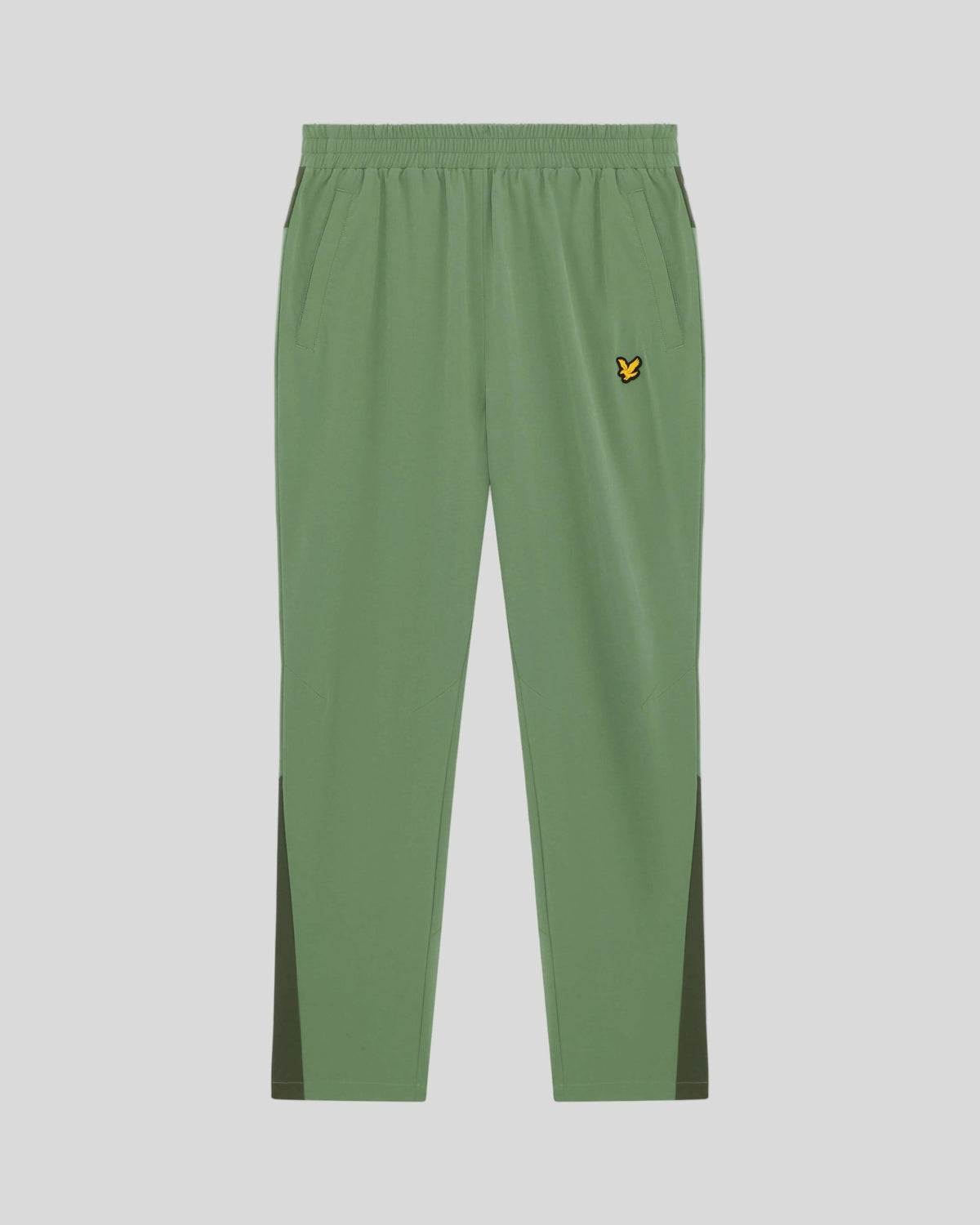 Man bär träningsbyxor med paneler i färgerna Botanical Green/Cactus Green