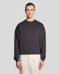 Mann trägt ein Relaxed-Sweatshirt mit Rundhalsausschnitt in der Farbe „Iron“