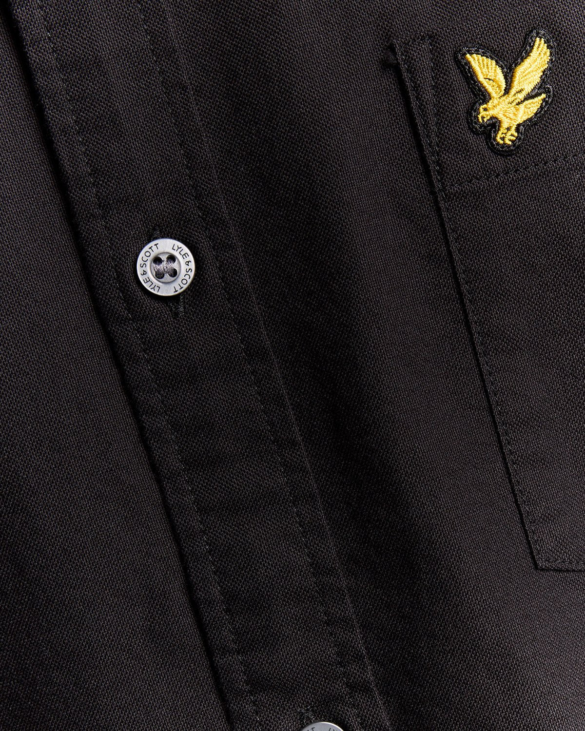 Un homme porte une chemise Oxford en coton à boutons, couleur noir de jais
