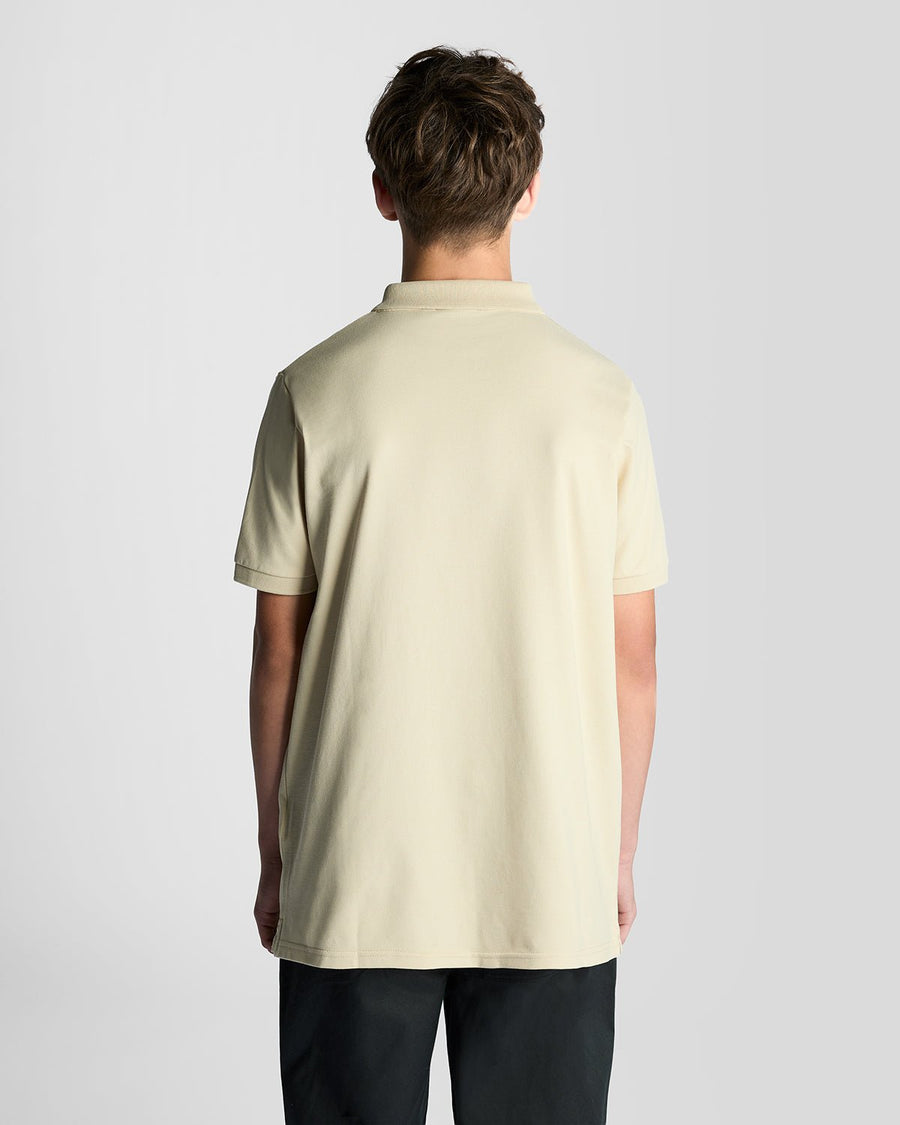 Un homme porte un polo en coton couleur blé