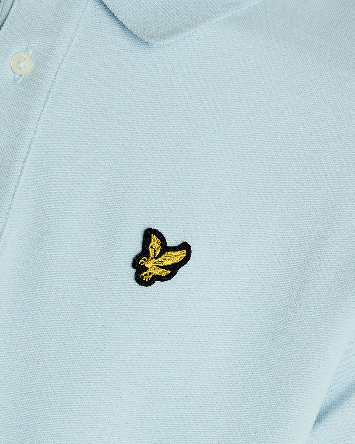 Un homme porte un polo en coton bleu opale