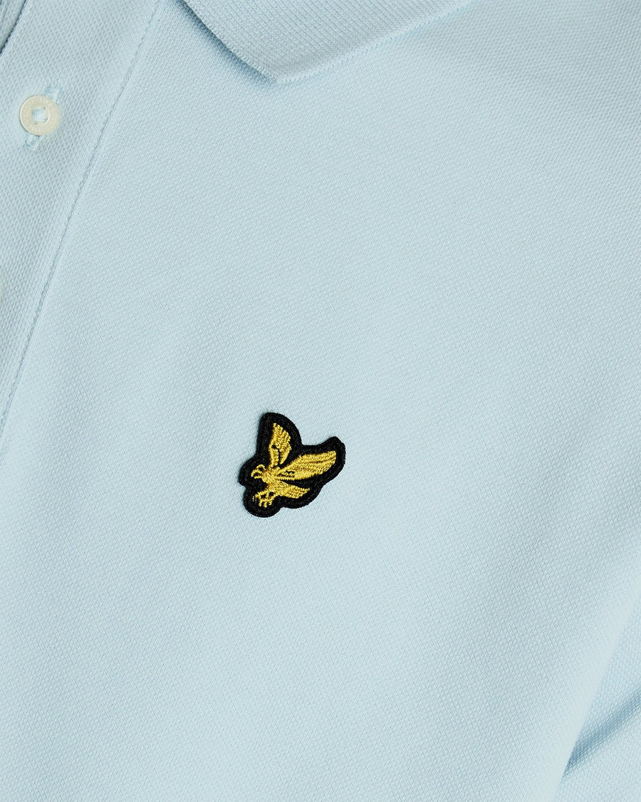 Un homme porte un polo en coton bleu opale