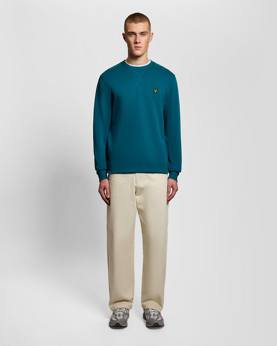 Un homme porte un sweat-shirt à col rond en coton, couleur Lagoon
