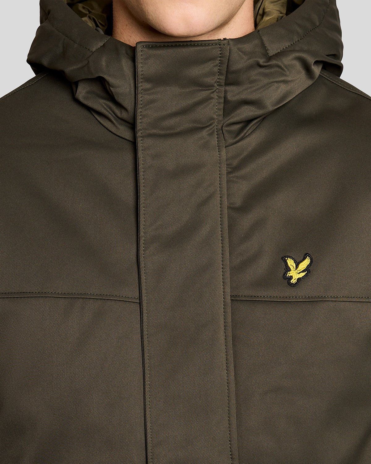 Un homme porte une parka matelassée de couleur olive