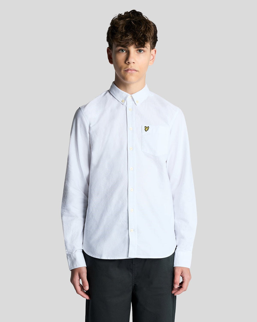 Un homme porte une chemise Oxford en coton à boutons, de couleur blanche