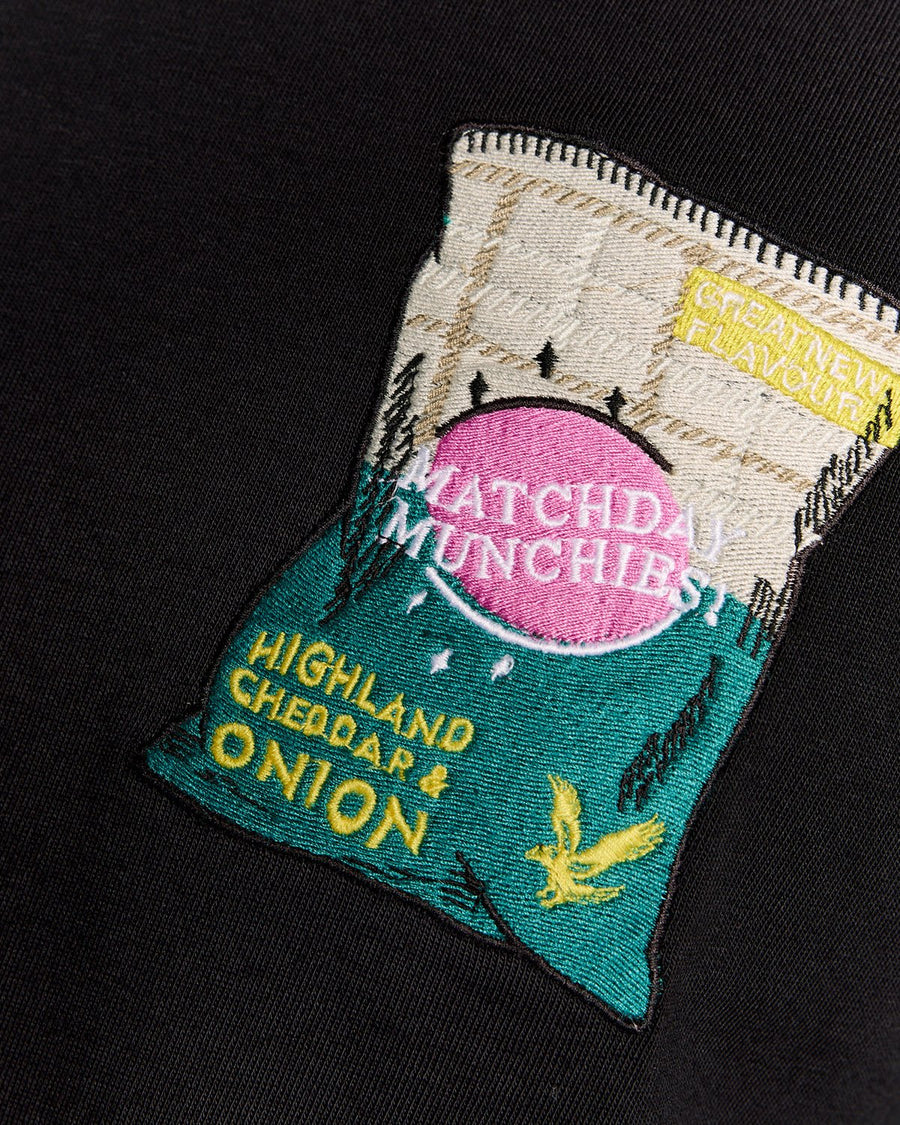 Homme portant un t-shirt à col rond avec motif brodé, couleur noir de jais