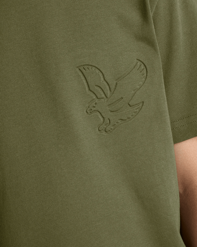 Un garçon porte un t-shirt « Embossed Eagle » dans les profondeurs