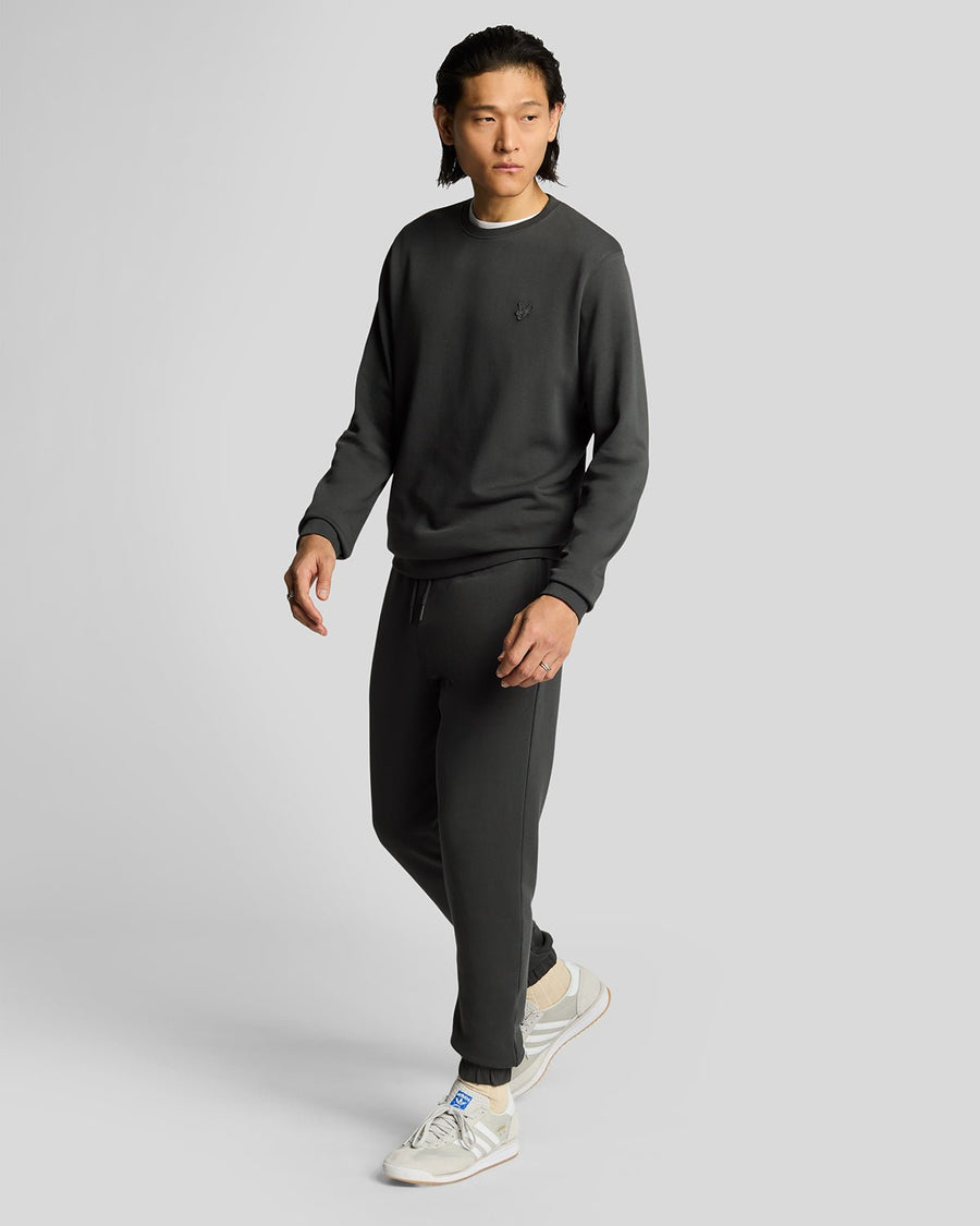 Un homme porte un pantalon de jogging slim en coton ultra-fin, couleur gris métallisé