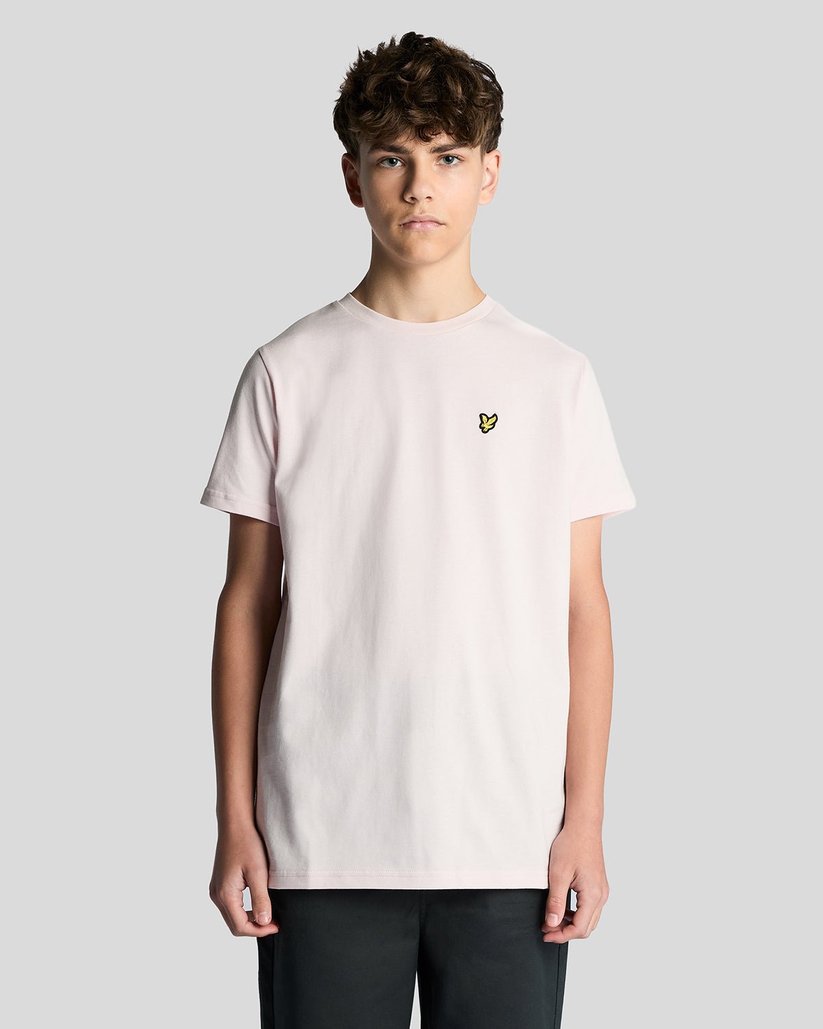 Un homme porte un t-shirt à col rond en coton rose pâle