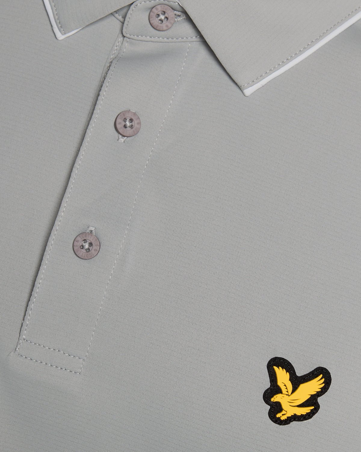 Un homme porte un polo à col contrasté de couleur « Ultimate Grey »