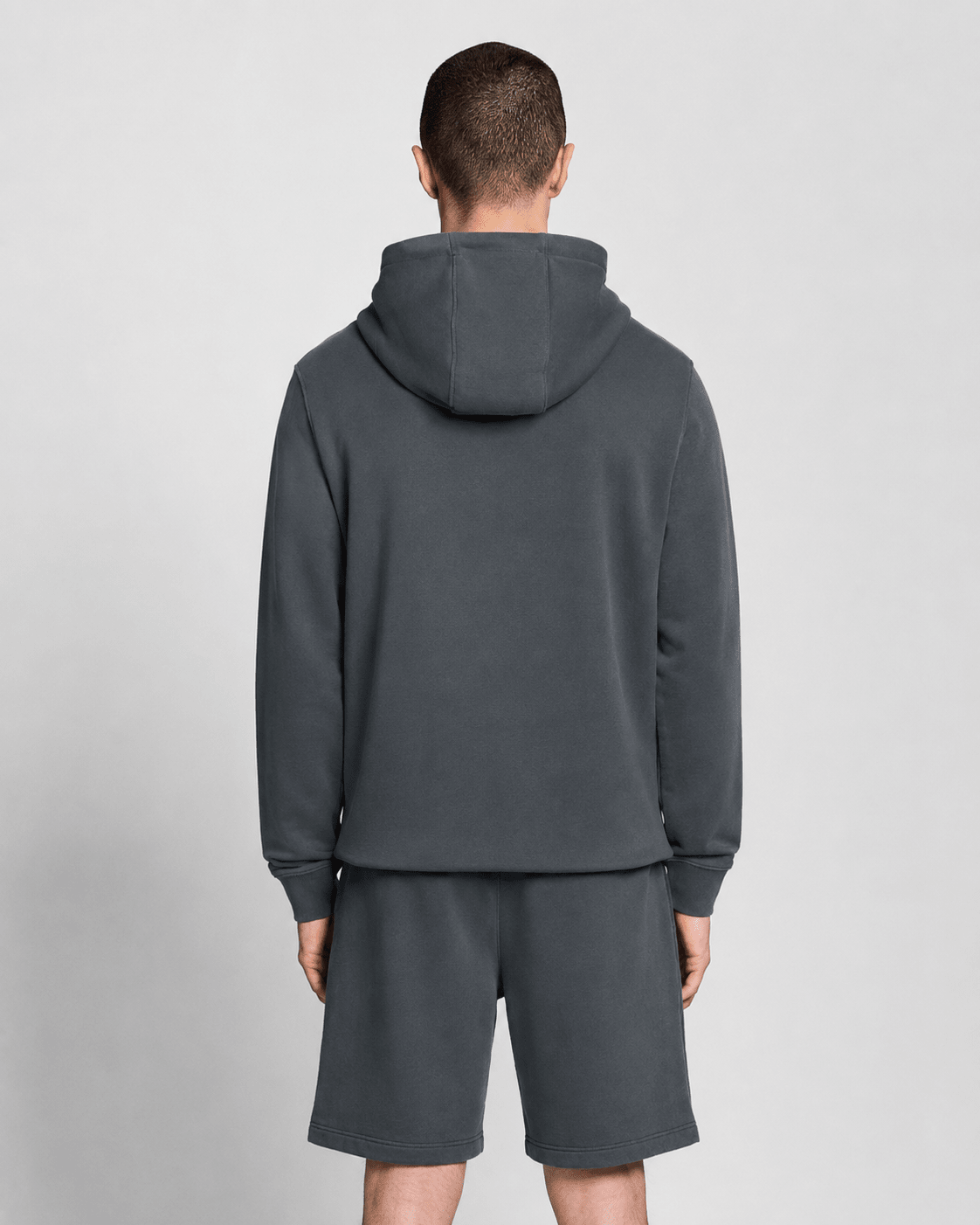 Homme portant un sweat à capuche en coton ultra-fin à effet bouclé, couleur « gunmetal »