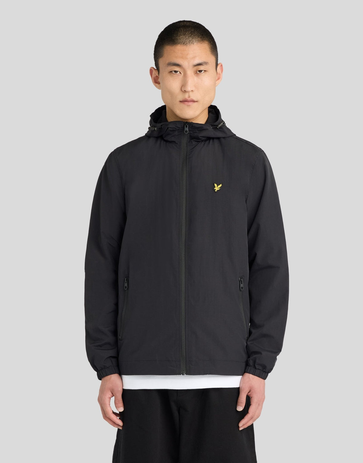 Hombre con chaqueta con capucha impermeable y costuras selladas en negro azabache