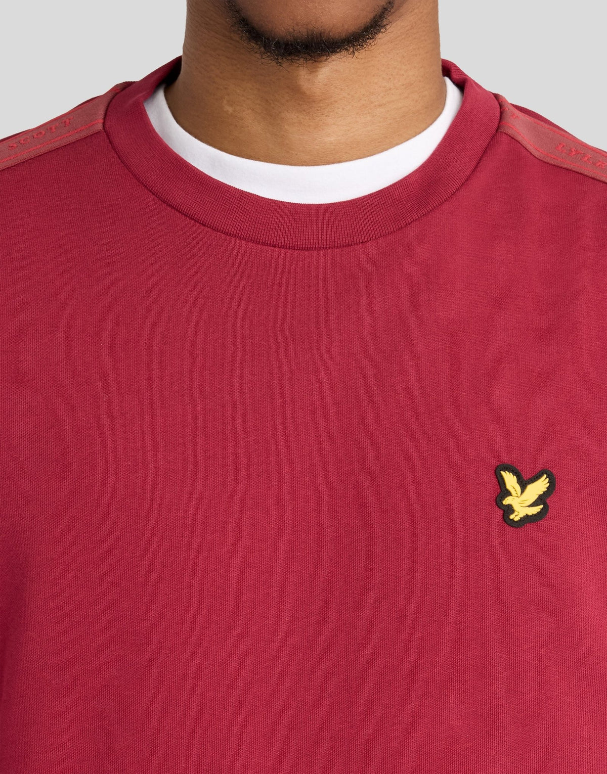 Man wears Sports Tape Crew Neck Sweatshirt in Plum