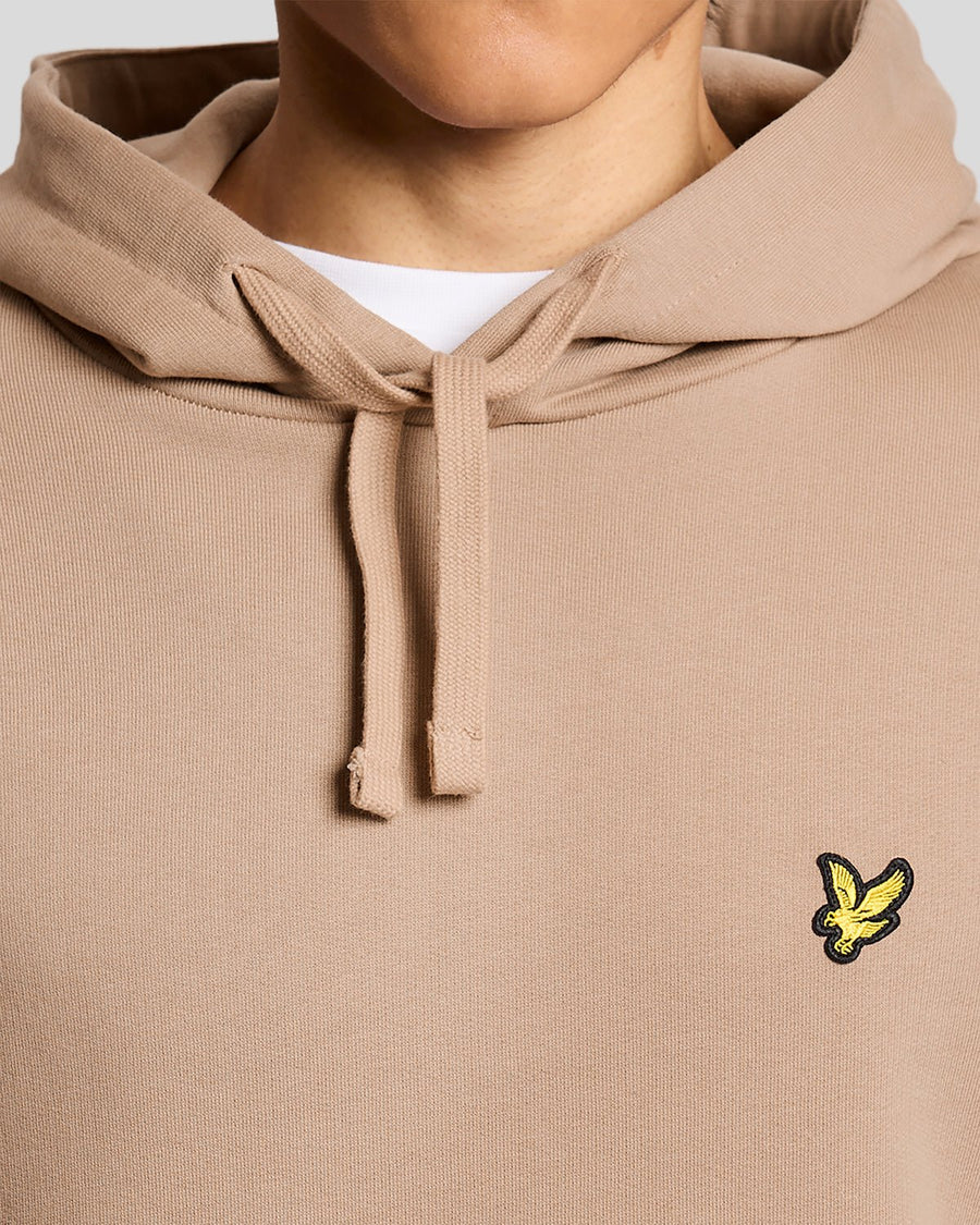 Un homme porte un sweat à capuche en coton Loopback, couleur Barley