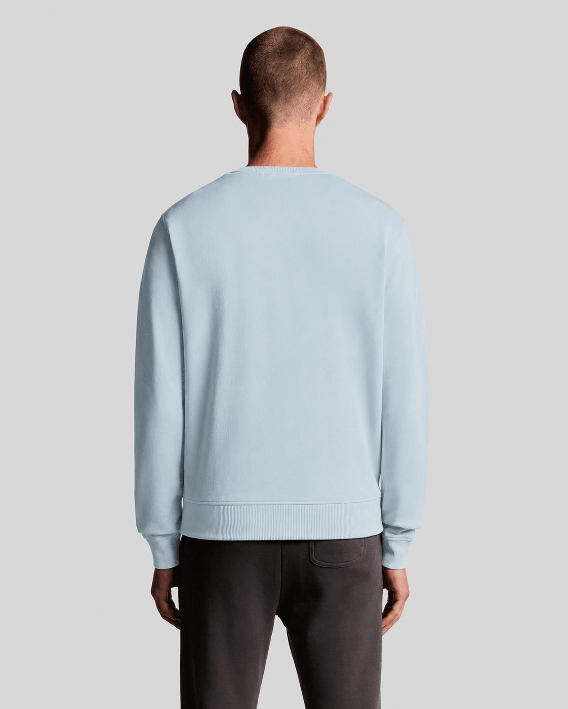 Hombre lleva una sudadera de cuello redondo de algodón en color azul ópalo.