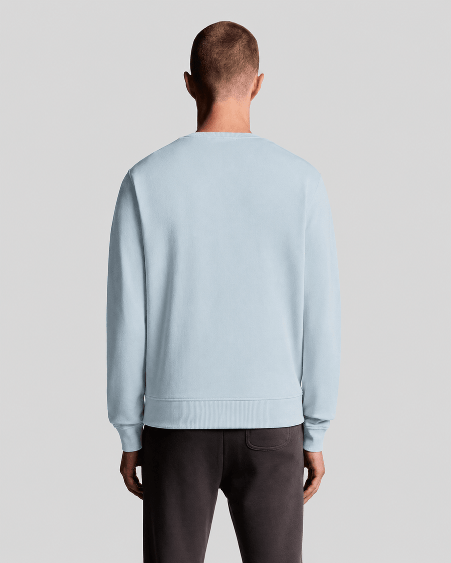 Hombre lleva una sudadera de cuello redondo de algodón en color azul ópalo.