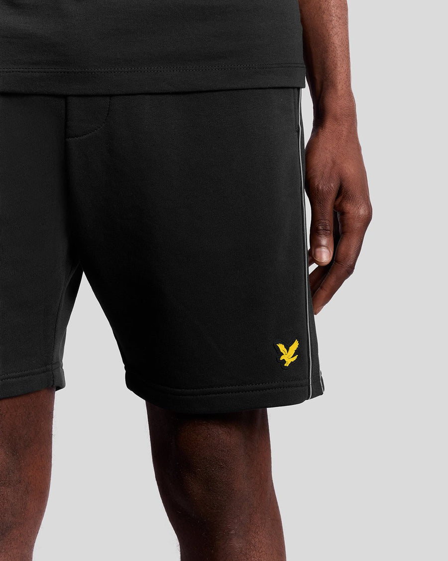Homme portant un short de sport en bande adhésive, couleur noir de jais