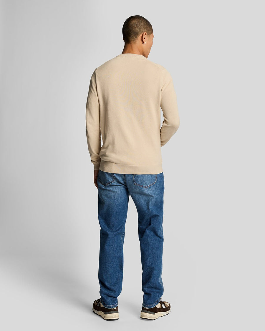 Homme portant un jean en denim ajusté et fuselé, bleu délavé