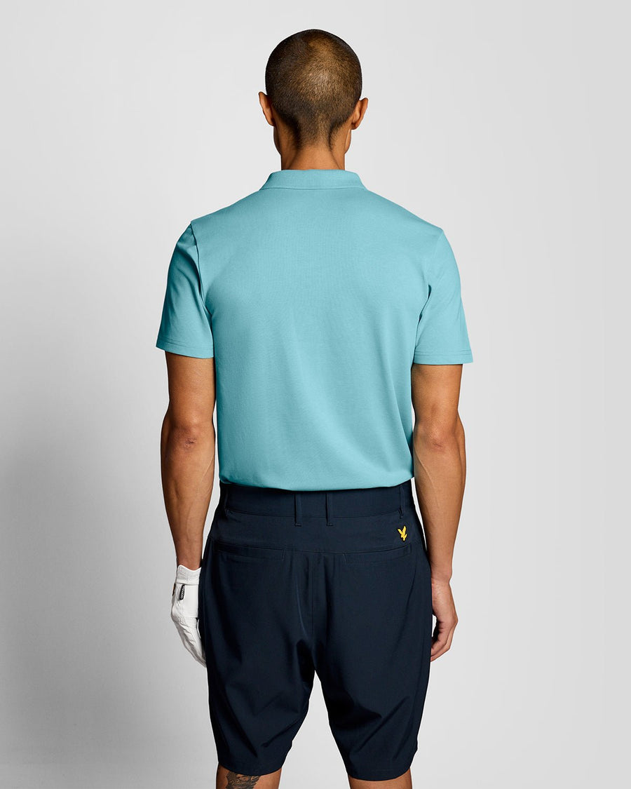 Un homme porte un polo technique bleu aquamarine