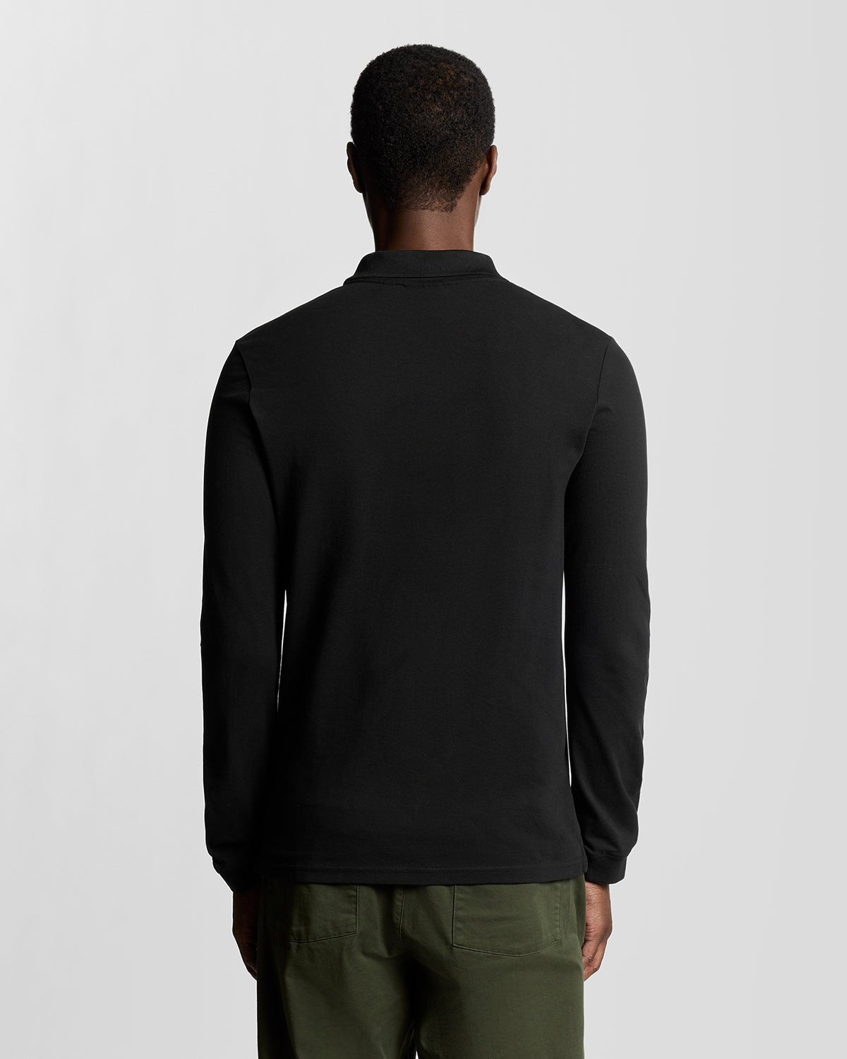 Homme portant un polo en coton à manches longues, couleur noir de jais