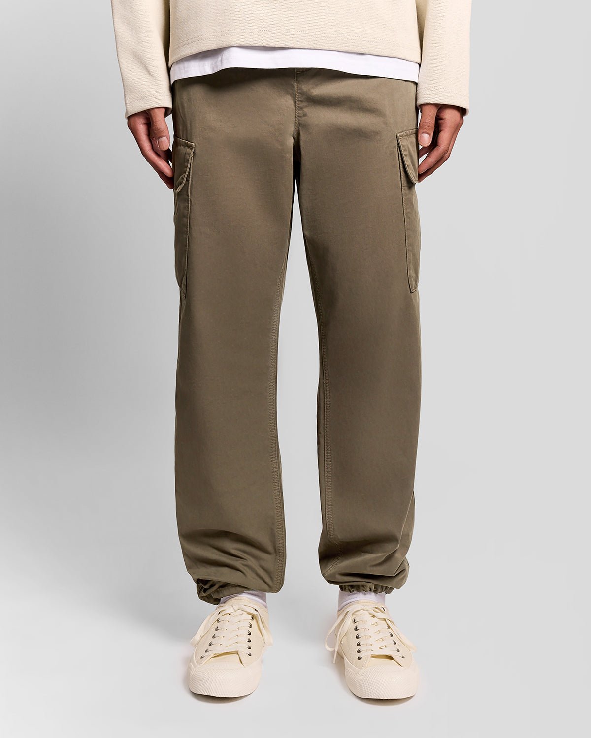 Un homme porte un pantalon cargo à revers de couleur kaki cendré