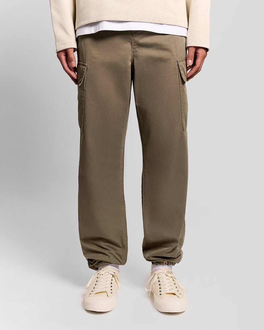 Un homme porte un pantalon cargo à revers de couleur kaki cendré