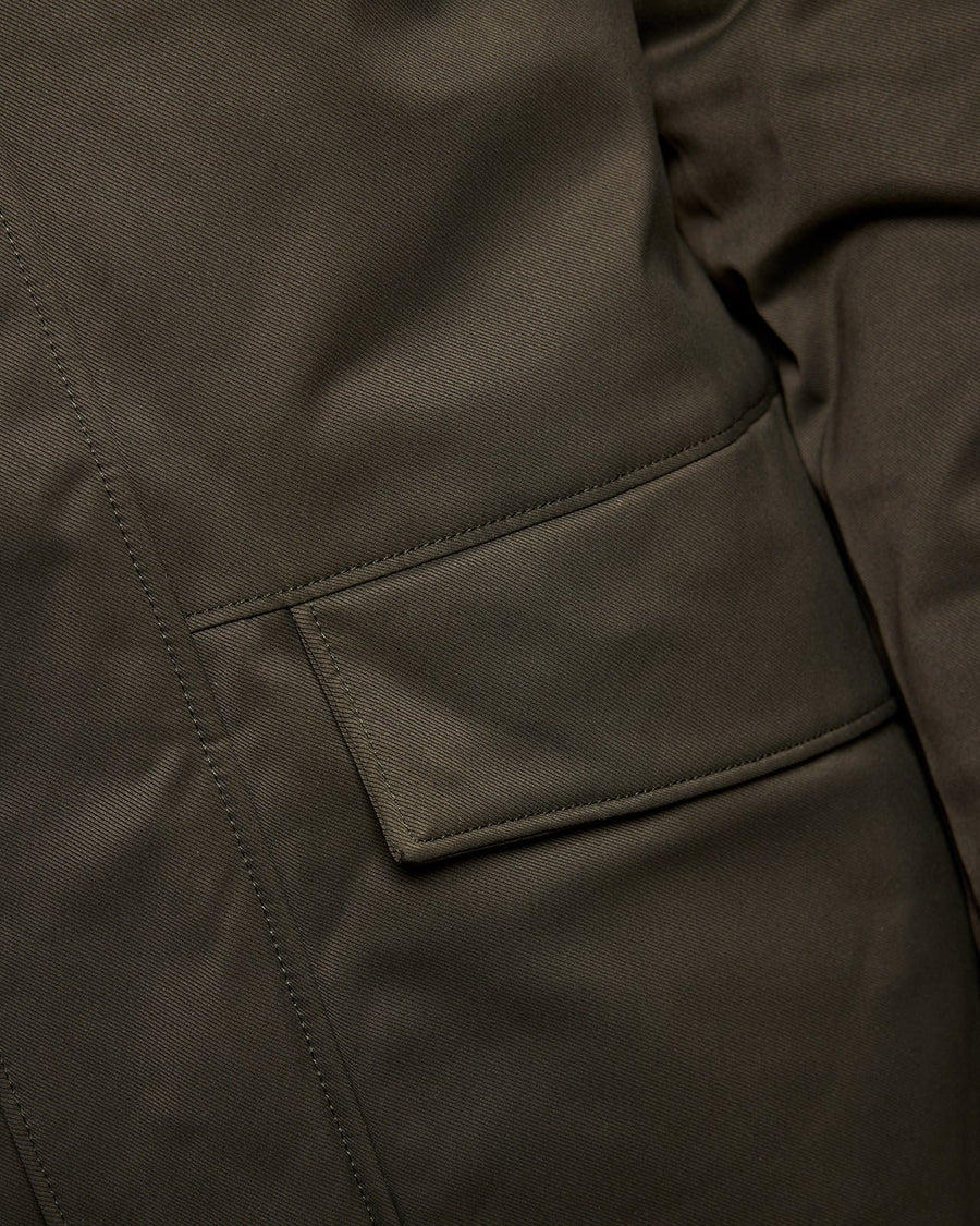 Un homme porte une parka matelassée de couleur olive