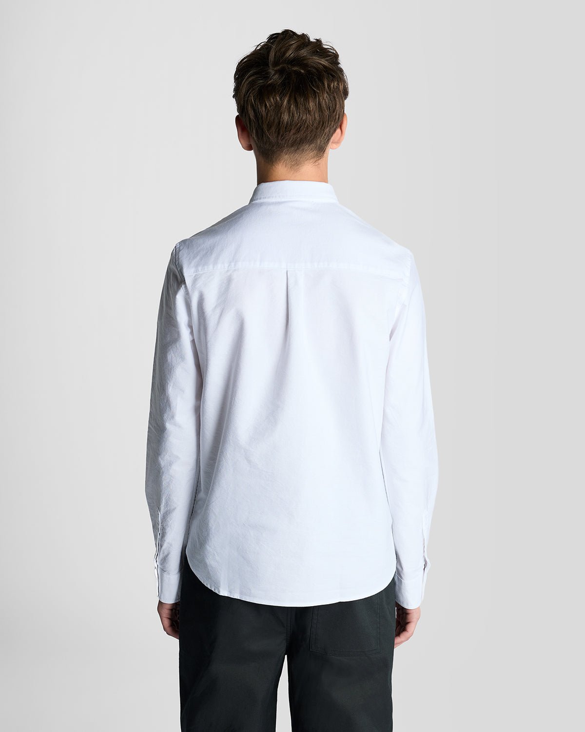 Un homme porte une chemise Oxford en coton à boutons, de couleur blanche