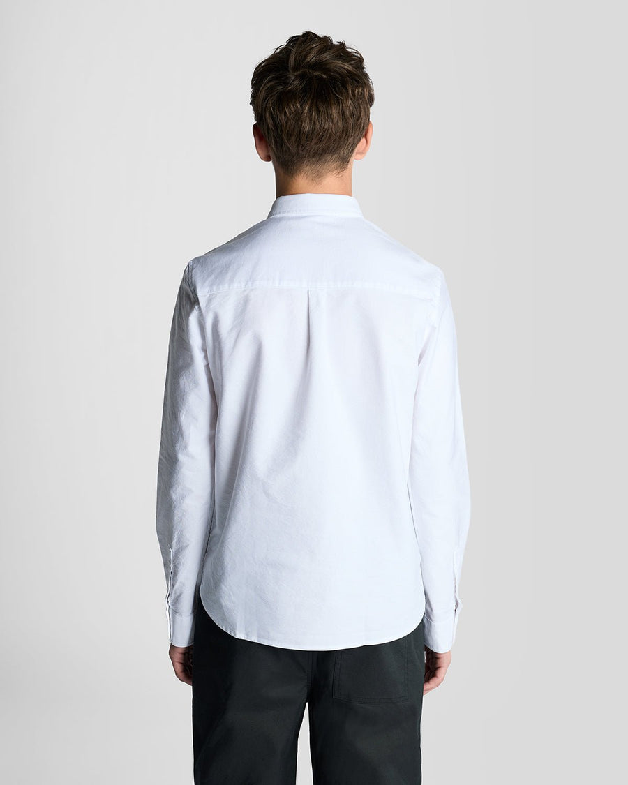 Un homme porte une chemise Oxford en coton à boutons, de couleur blanche